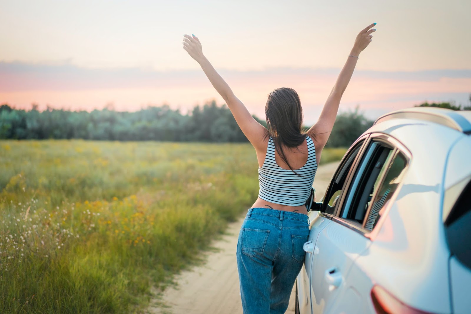 A girl traveling by a car as a budget-friendly adventure travel