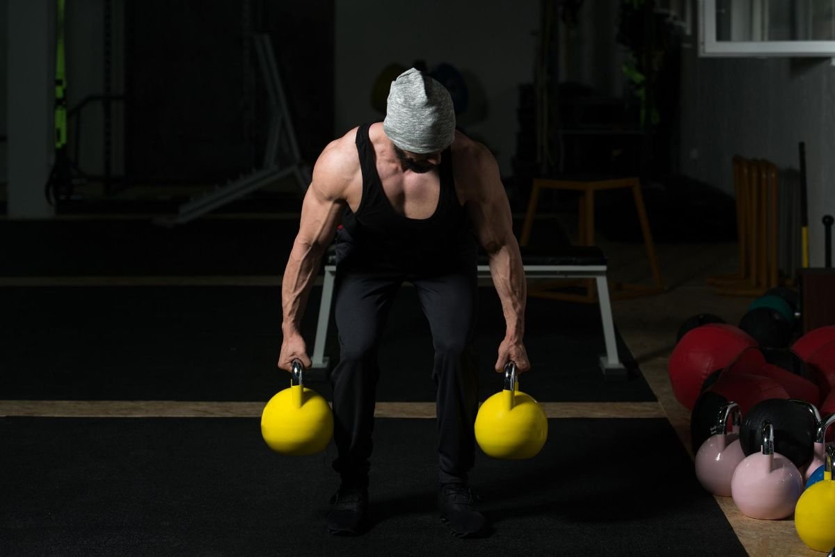 homem forte fazendo exercicio deadlifts com kettlebell