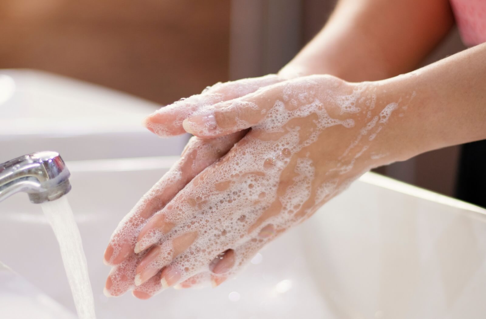 A close-up of a person's hands lathered with soap.