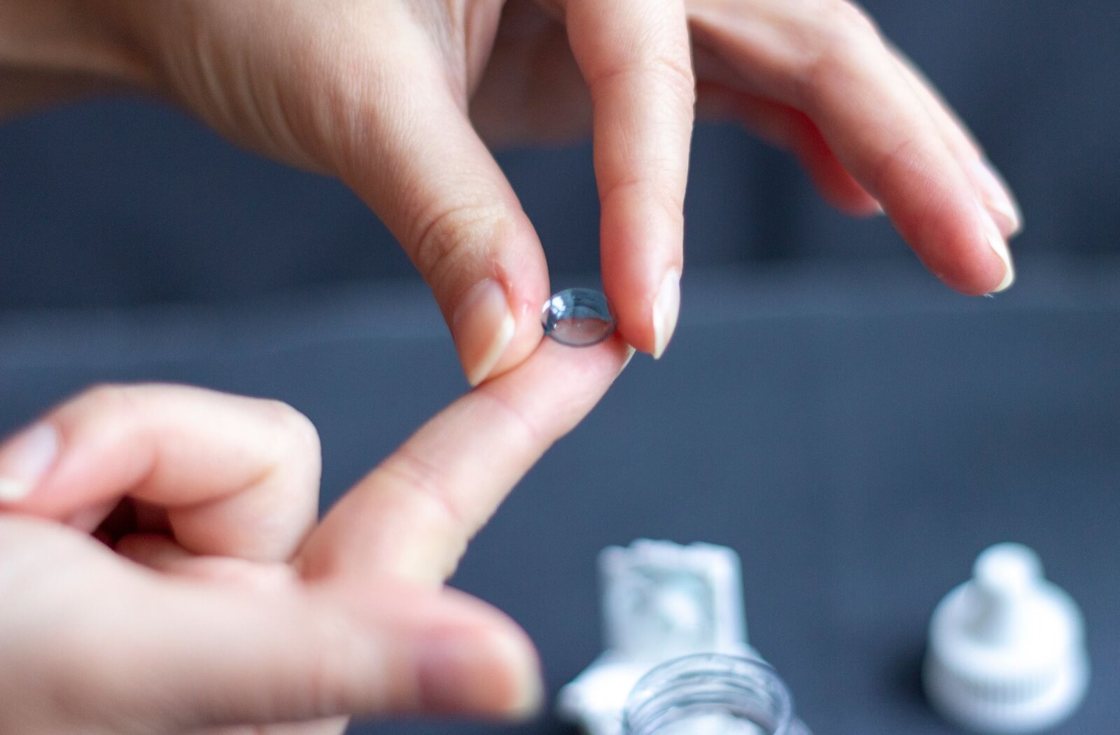 A close-up of an Orthokeratology lens on an index finger.
