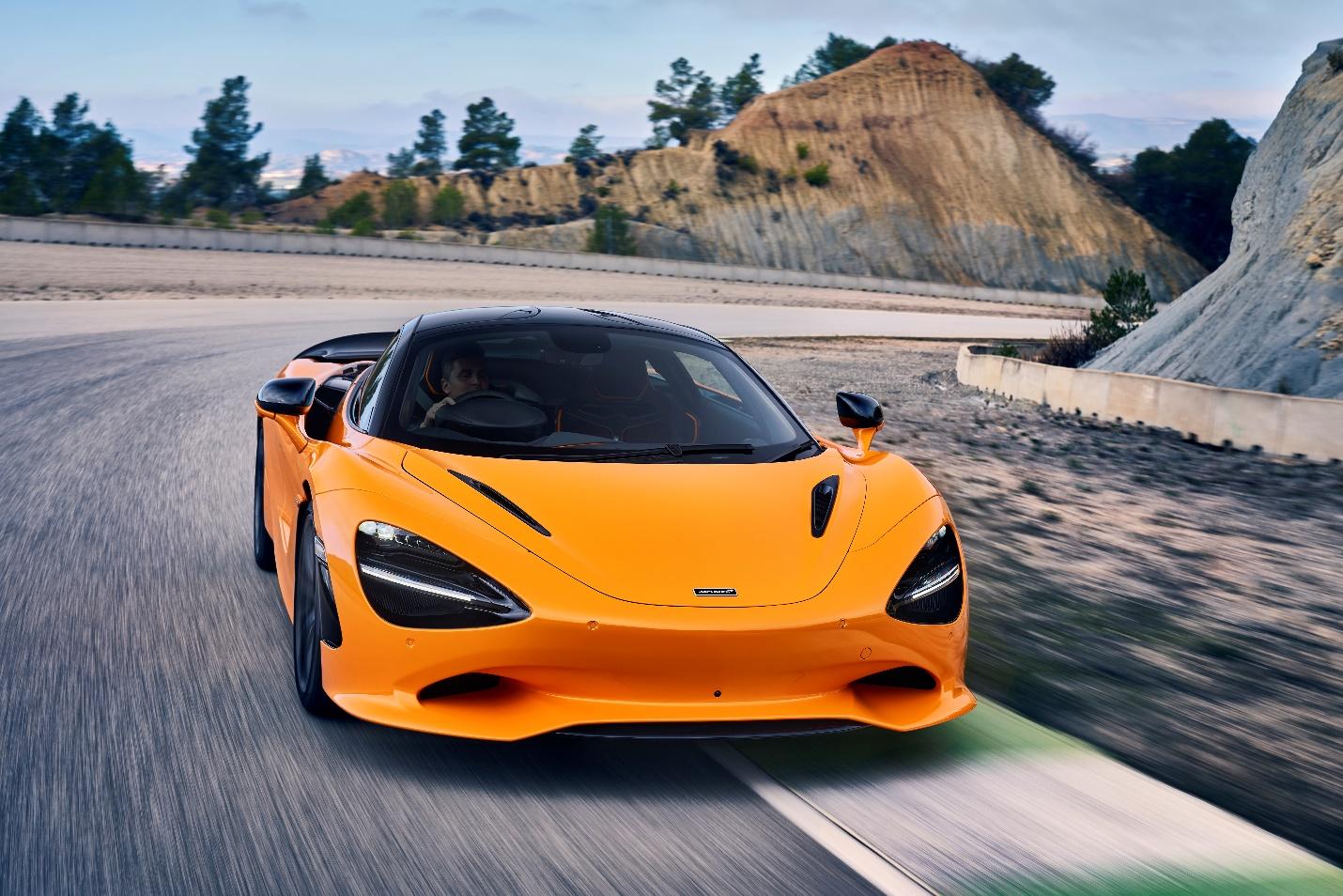 A yellow sports car on a road

Description automatically generated