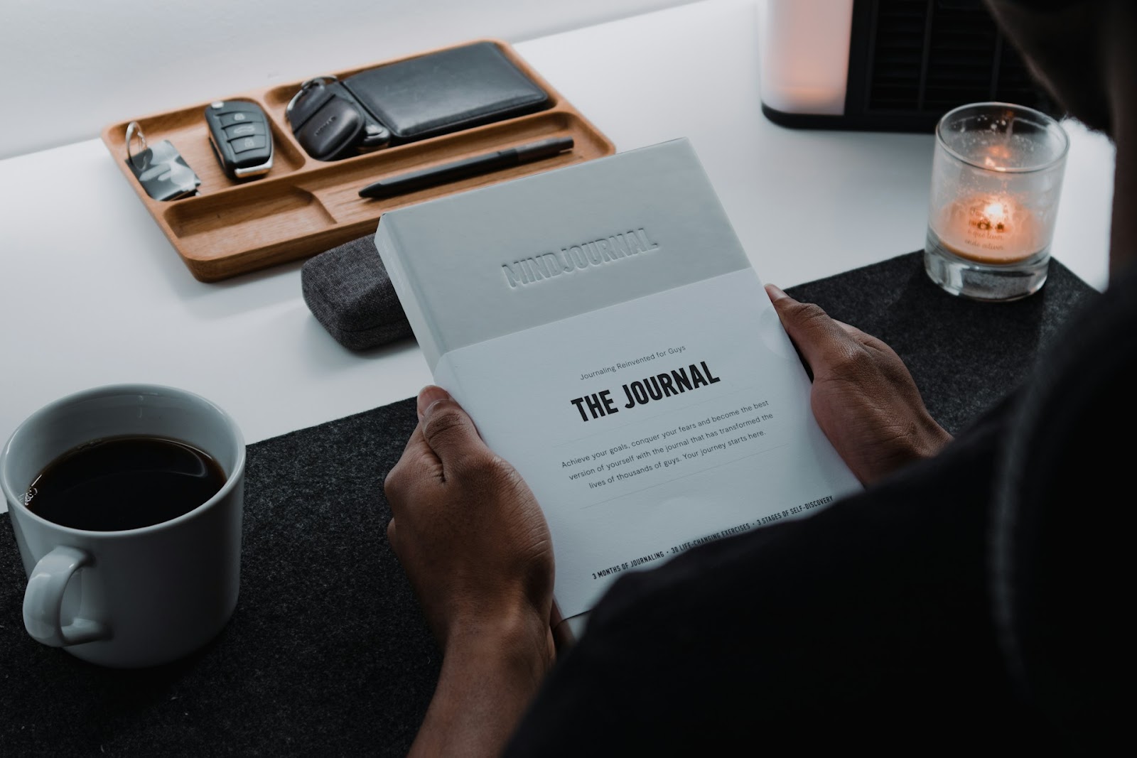 A man holding a book with the Title "The Journal"