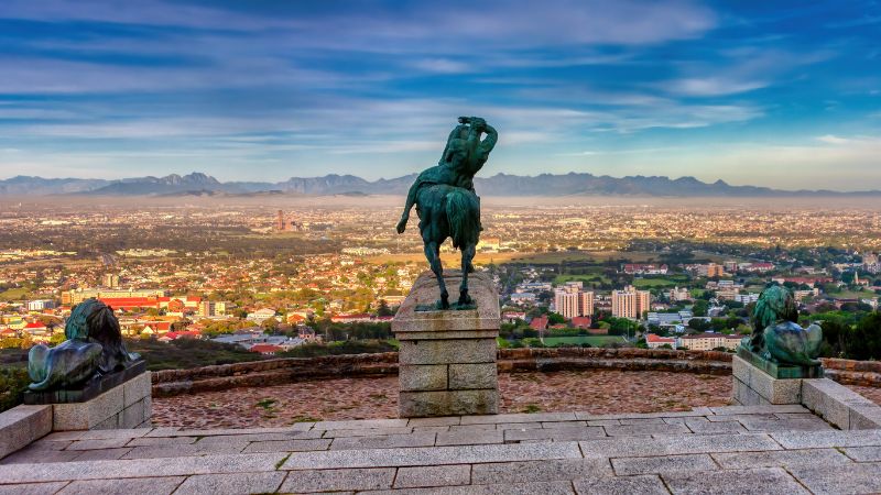 A photo of the statues at Rhodes Memorial, overlooking the panoramic view of Cape Town and the distant mountains.