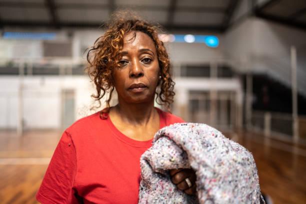 portrait of a senior woman holding a blanket at a community center - black woman stress stock pictures, royalty-free photos & images