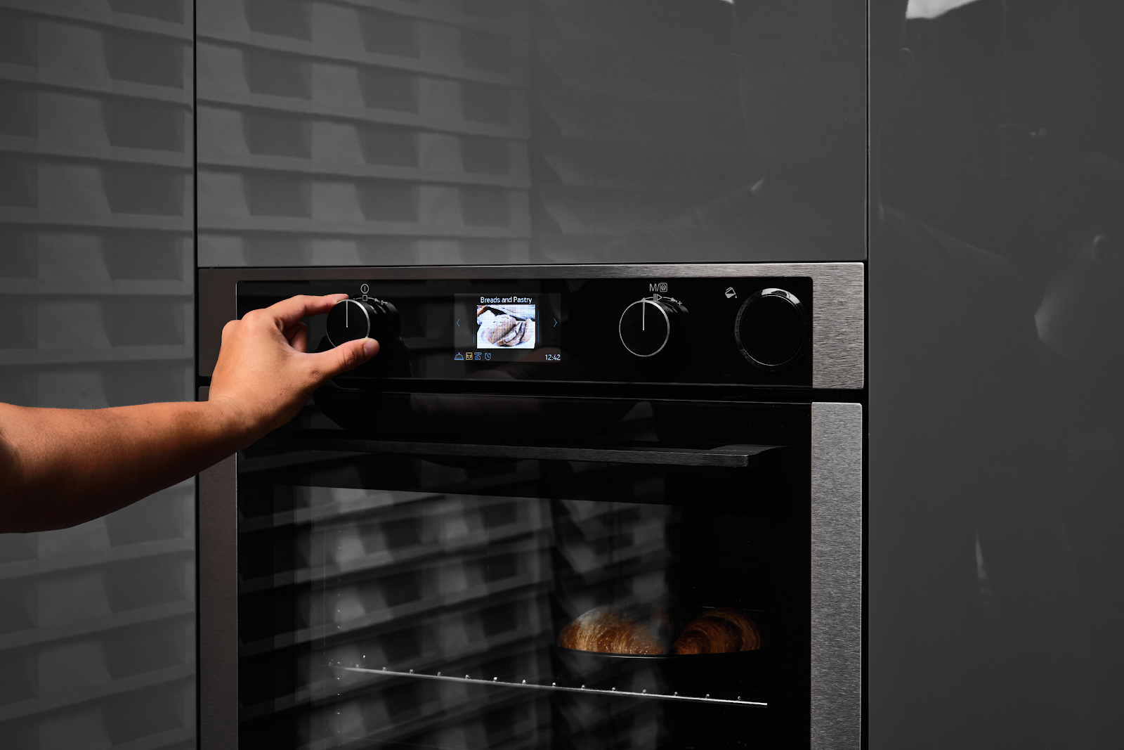 A hand turning a knob on an oven

Description automatically generated