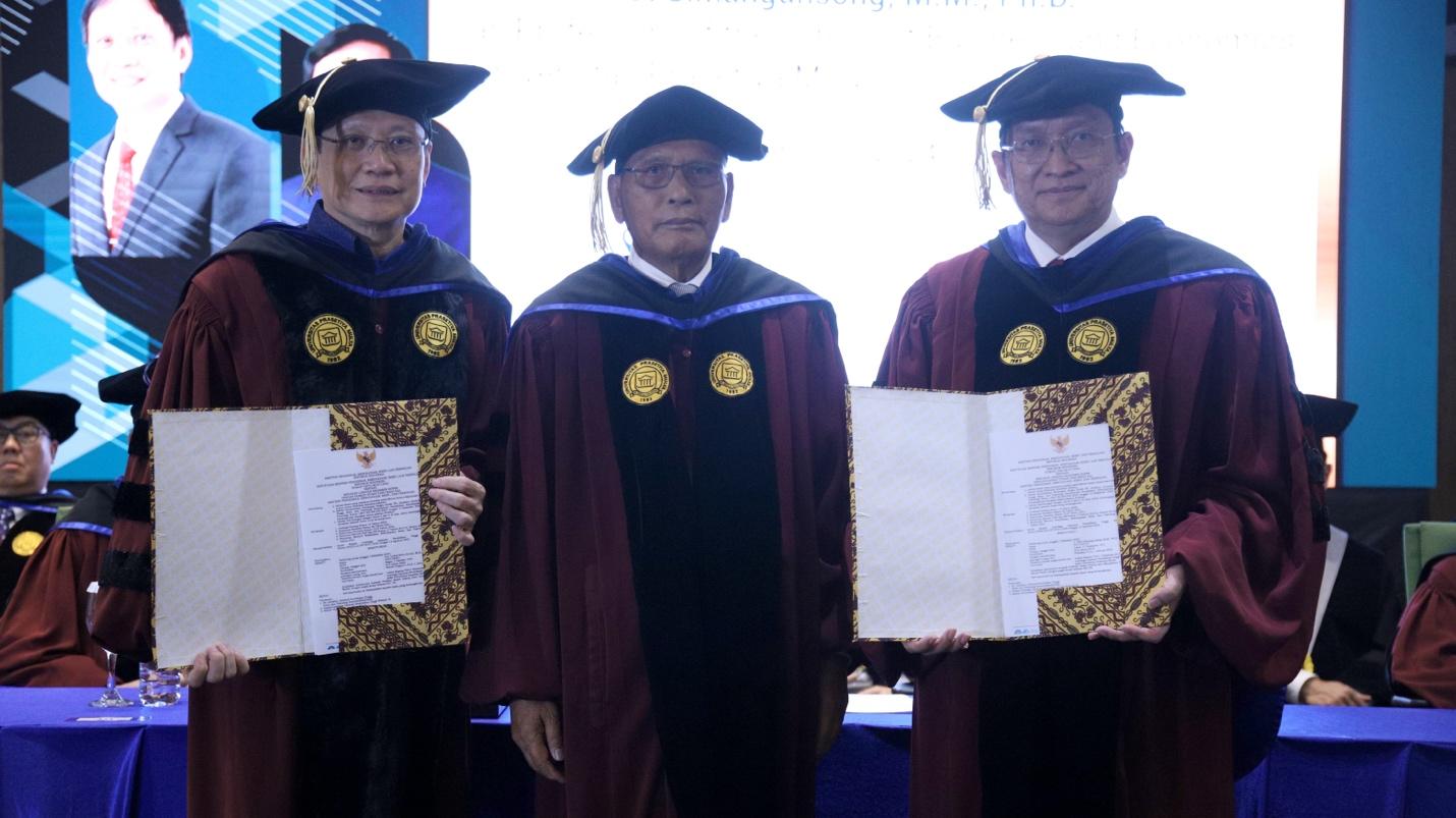 A group of men in graduation gowns holding papers

Description automatically generated
