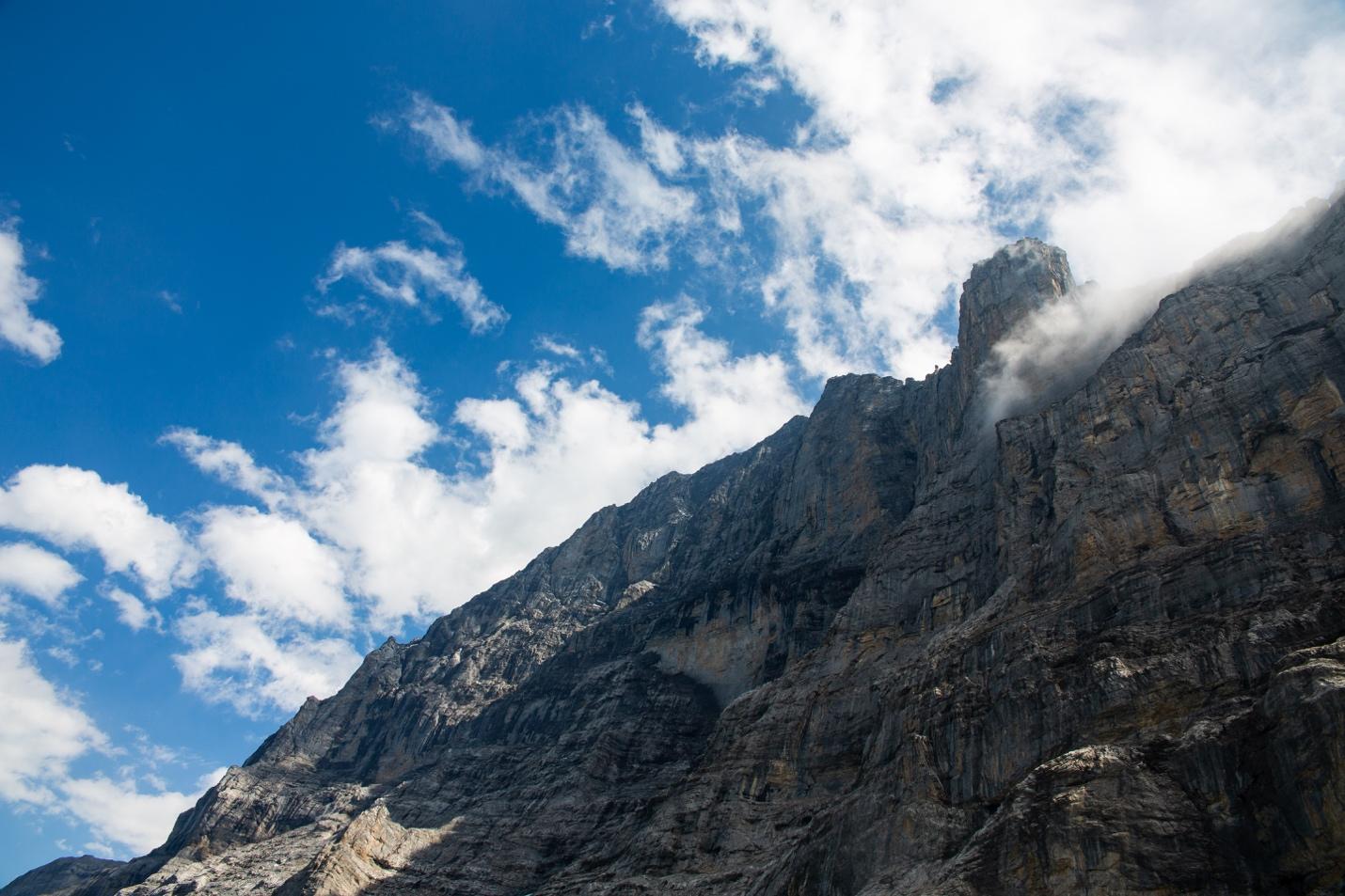 A mountain with clouds in the sky

Description automatically generated