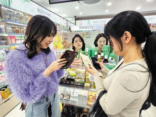 23일 서울 명동 다이소 매장을 찾은 일본인 관광객들이 화장품 코너에서 마스크팩과 에센스 등을 살펴보고 있는 모습. 오프라인 매장을 기반으로 한 다이소는 저렴하면서 젊은층 트렌드에 맞는 제품들을 꾸준히 선보이며 온라인 커머스 시대에도 상승세를 이어가고 있다.
/다이소