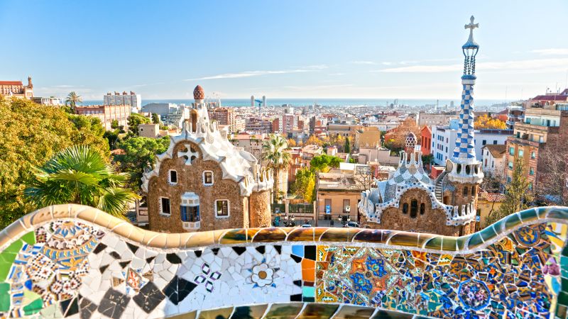 Madrid vs Barcelona - Overlooking Barcelona, with Park Güell's mosaic bench in the foreground.