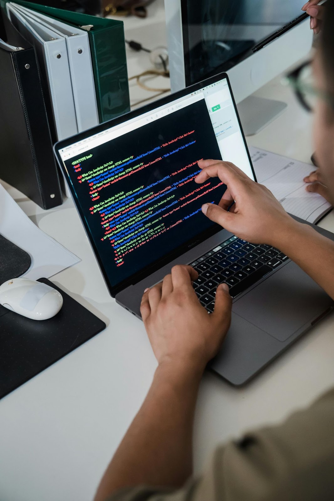 An IT professional examining code on a laptop.