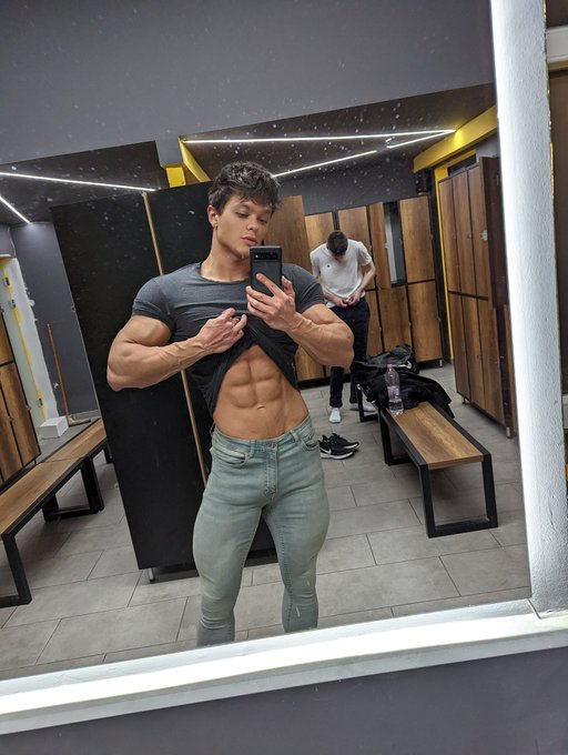 gay male onlyfans creator showing off his washboard abs in the gym locker room and his hot big bulge in his skinny jeans