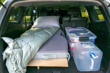 A bed in the back of a car

Description automatically generated