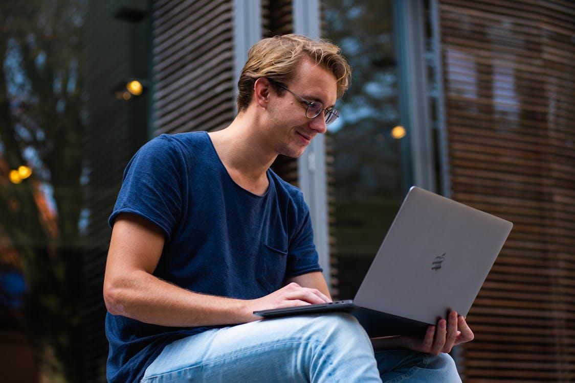 Free Selective Focus Photo of Man Using Laptop Stock Photo