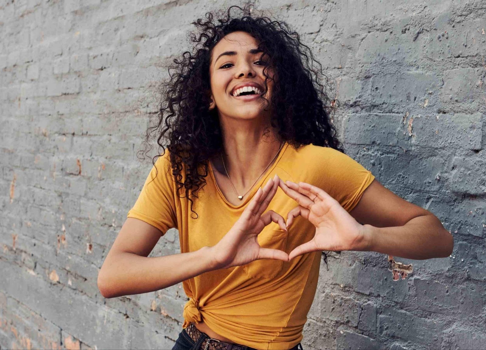 yellow shirt girl making a heart