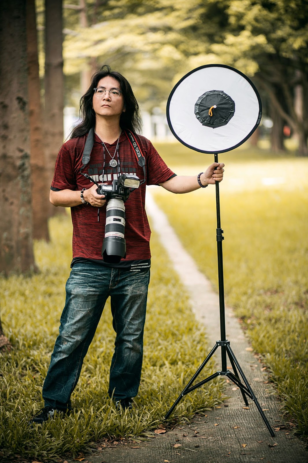 A photographer standing in an outside setting with equipments for a professional photoshoot