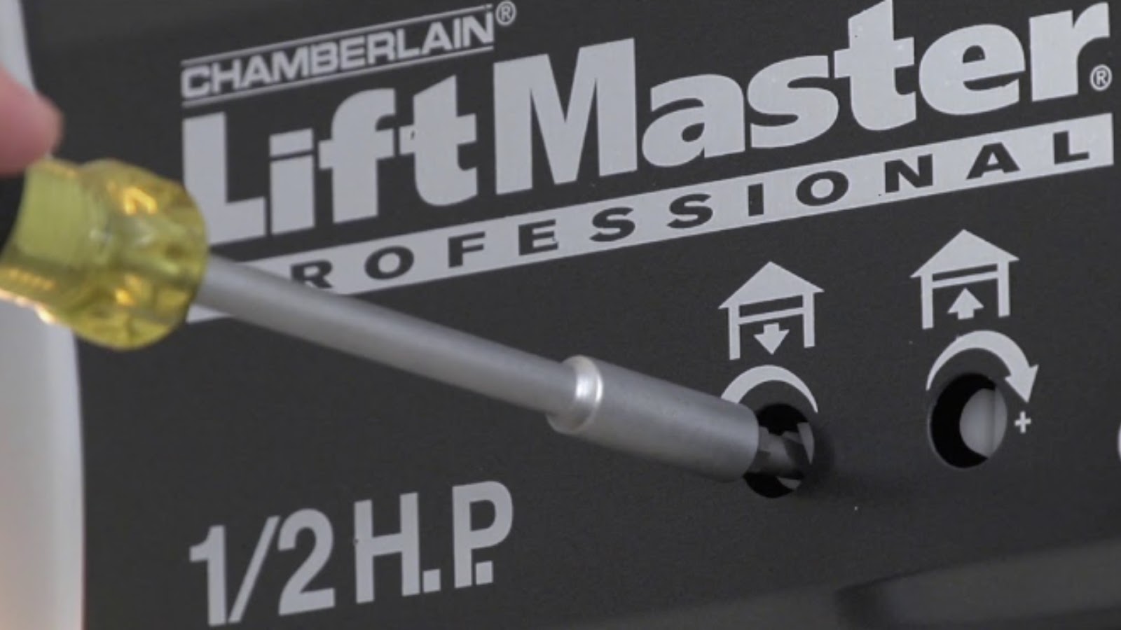 A technician adjusting a door opener's travel limits