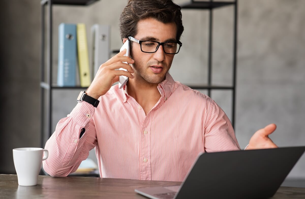 Claims process automation: manager talking on the phone while looking at his laptop