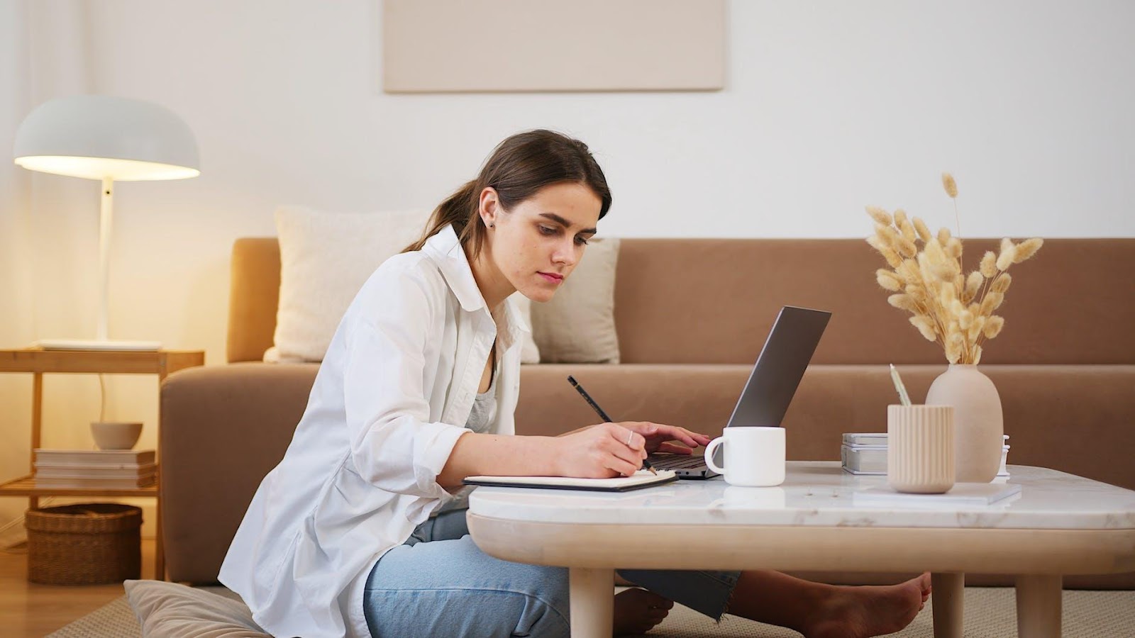 Side view of a focused student browsing a modern laptop for exam preparation