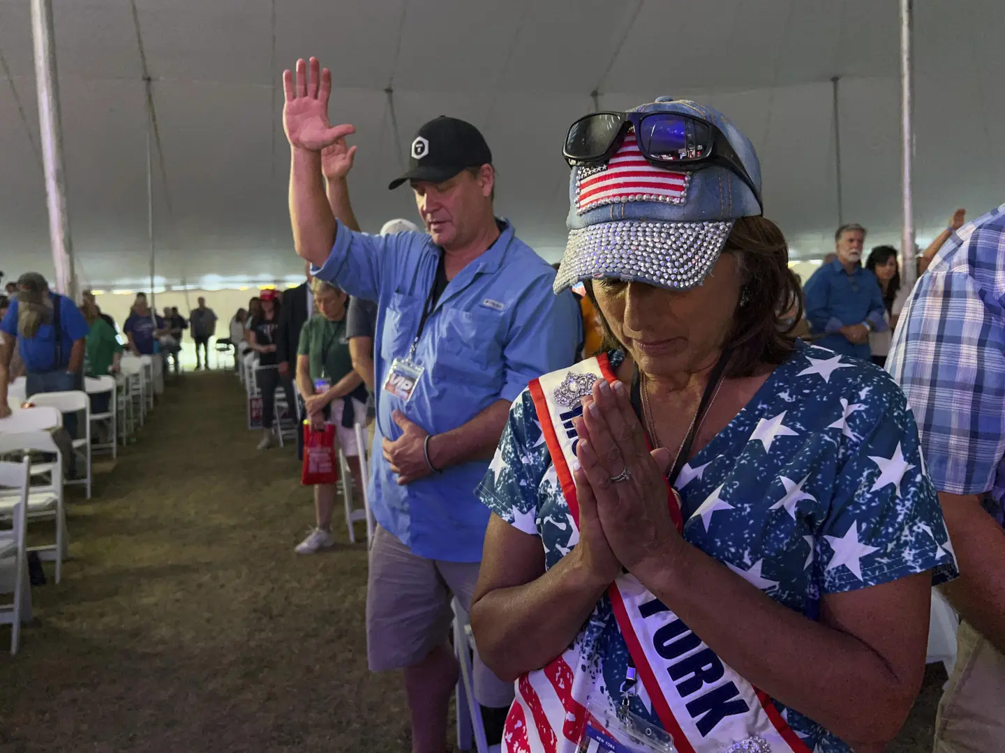 Les spectateurs priant pour Donald Trump en août 2022, à Batavia (New York). © Caroline Kaster / AP