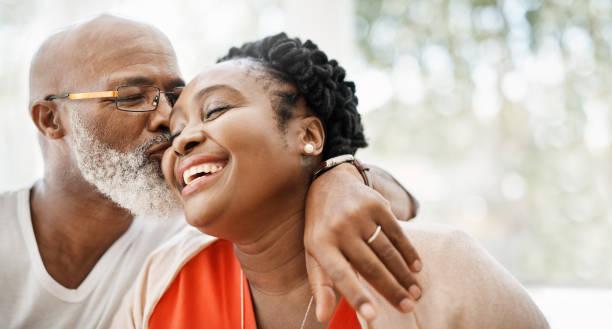 The greatest gift I ever got was you Shot of a mature man affectionately kissing his wife at home husband wife stock pictures, royalty-free photos & images