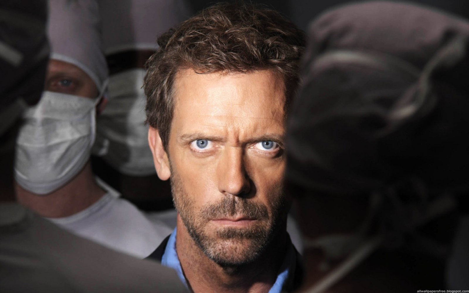 Dr. House (Hugh Laurie) de pie entre las siluetas de otros doctores con mascarillas.