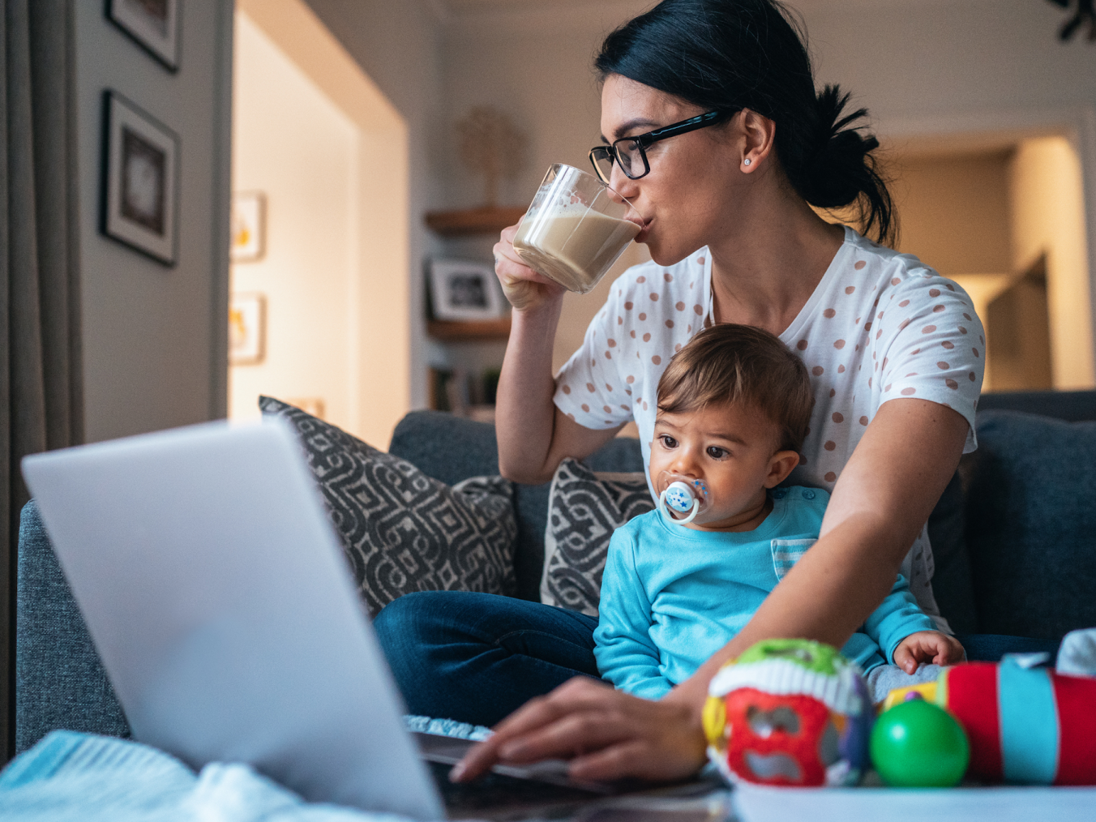 Remote working mother works while taking care of her baby