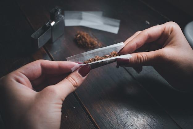 High angle shot of a female rolling a joint