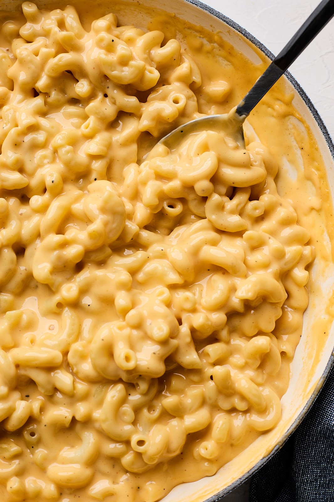A close up of homemade velvetta mac and cheese recipe in a bowl being eaten