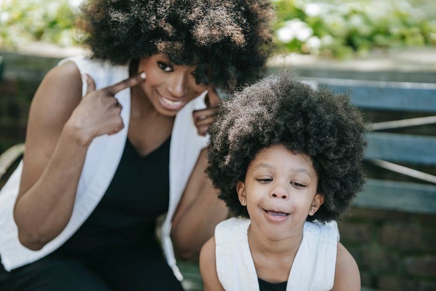 A woman and a young girl with Afro hairstylеs