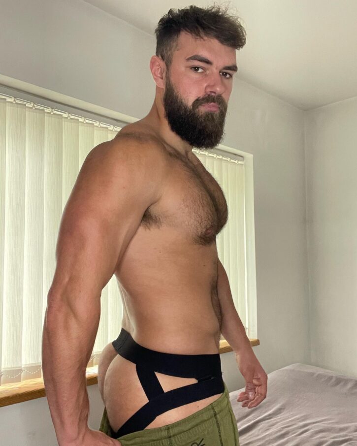 alpha bayton wearing a black jockstrap shirtless pulling down his pants to reveal his hairy ass