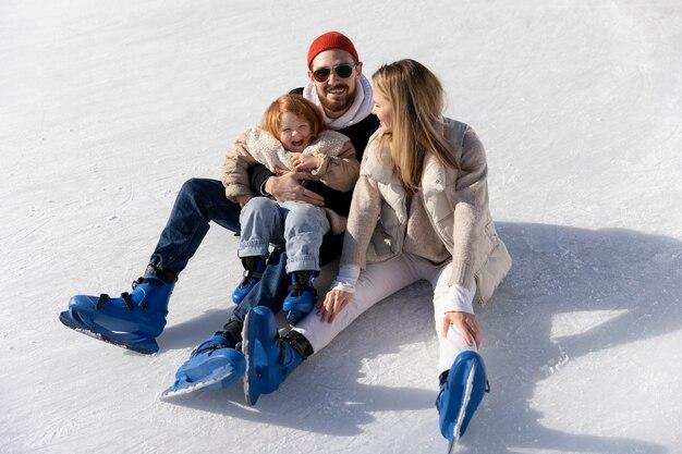 Free photo full shot happy family having fun at rink