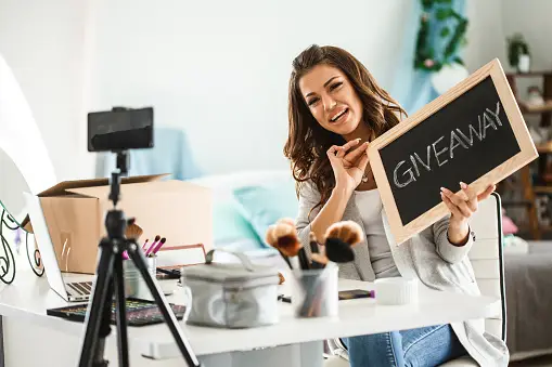 A Girl is Happily Showing Her Social Media Followers a Giveaway Board to Announce It 