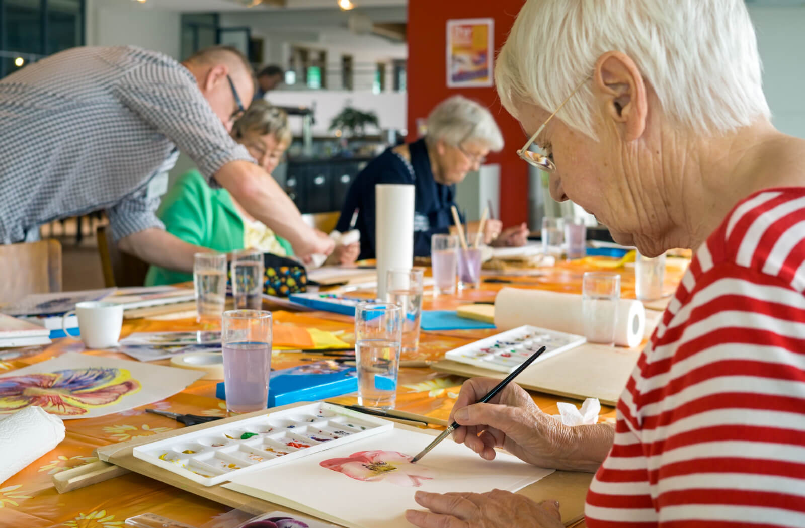 A group of older adult participating in an art class hosted by the personal care home.