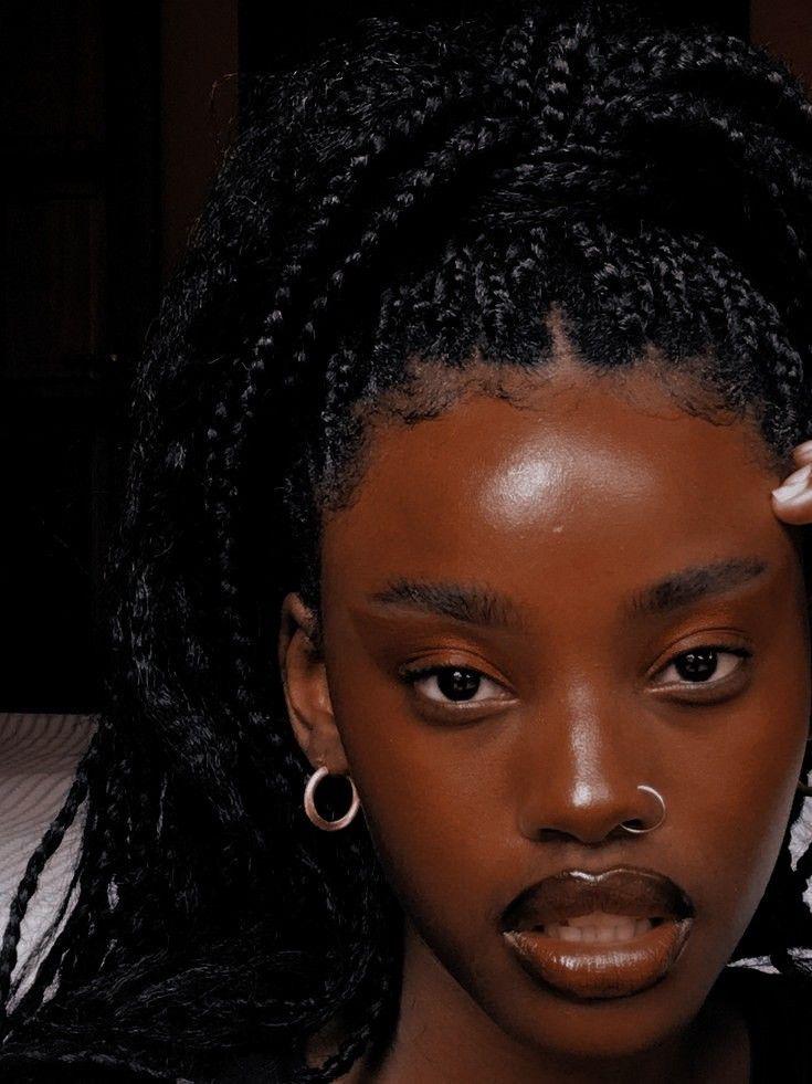 A black girl with piercings, whose makeup implements the soap brow style to perfection
