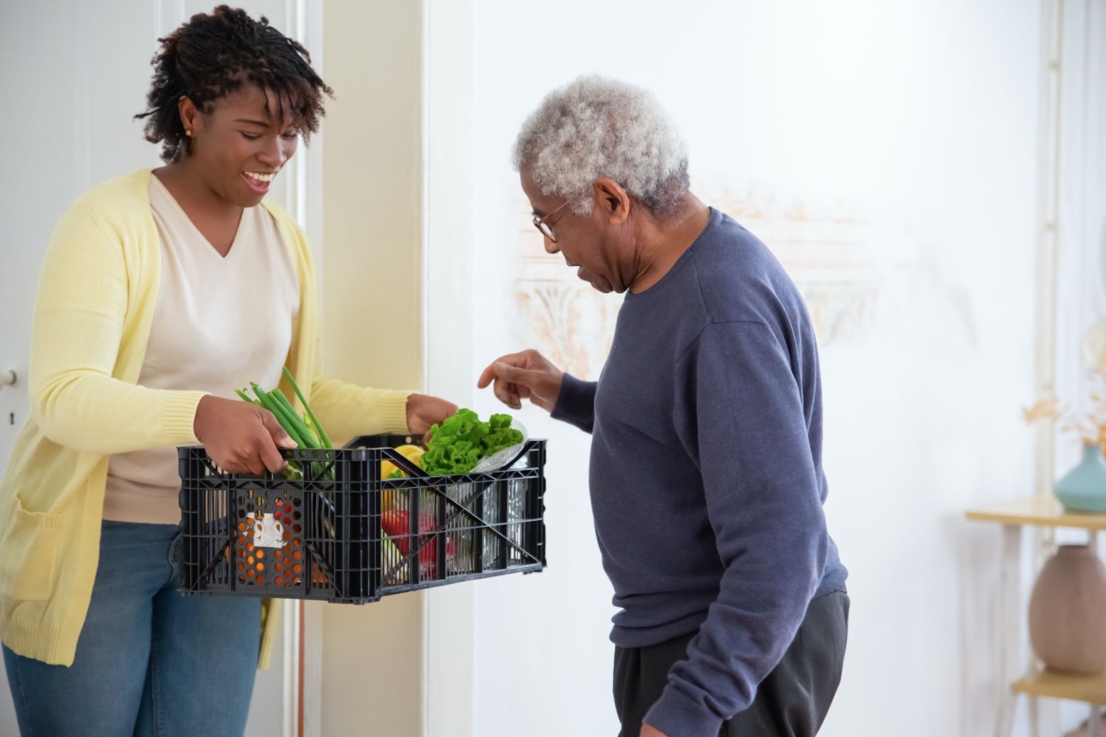 A senior citizen picking vegetables out of a basket and potentially receiving one of the 5 levels of care in assisted living