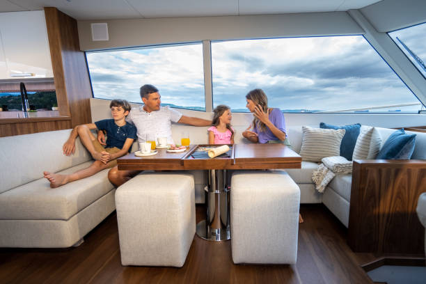 Family sitting at table in design interior of impressive yacht