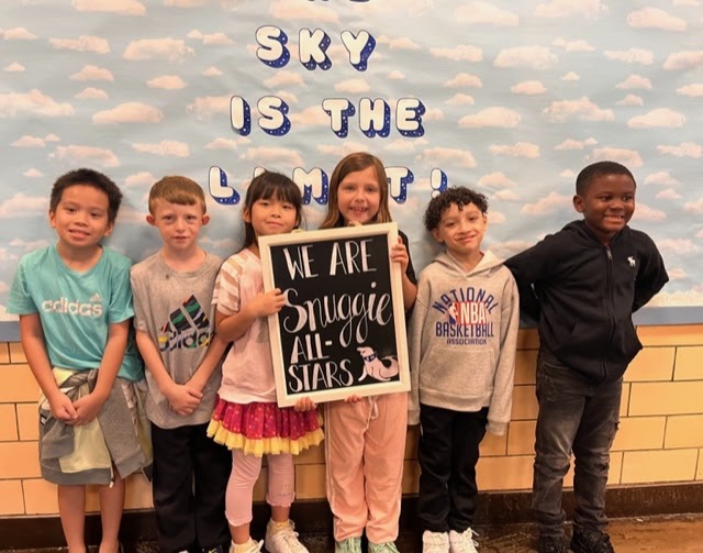6 Snug Harbor students pose with a sign that reads "We Are Snuggie All-Stars"