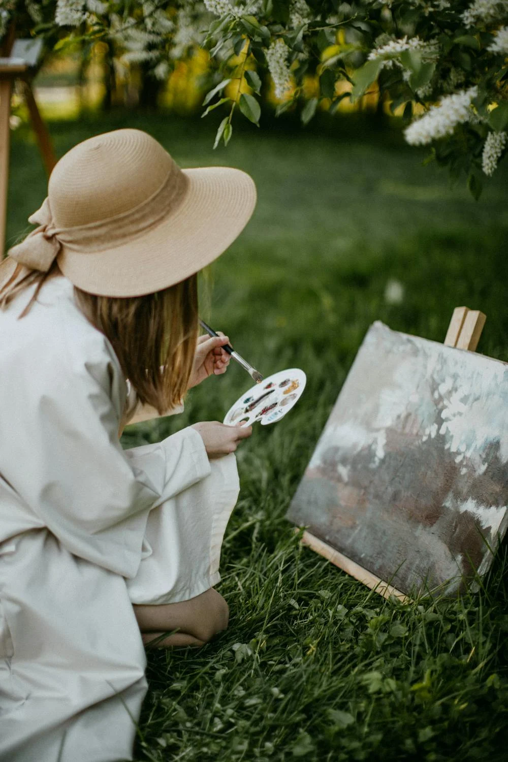 Woman painting on an art canvas outdoors.