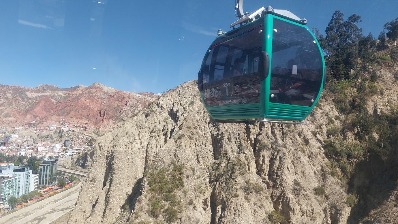 A gondola in the air over a rocky mountain

Description automatically generated with low confidence