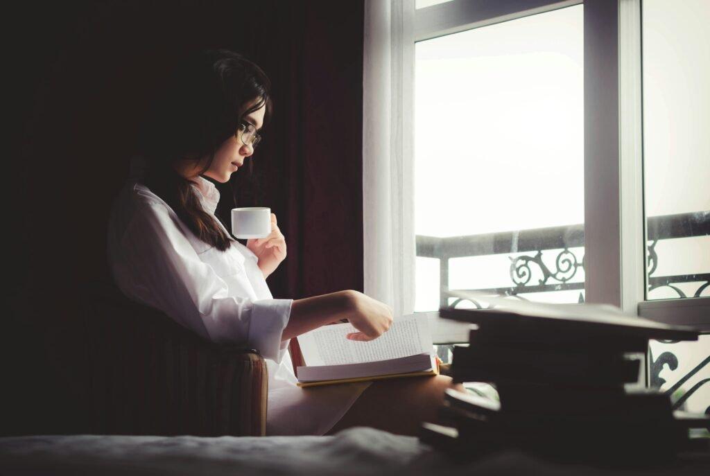 woman reading a book by the window - Best Study Methods For Adhd