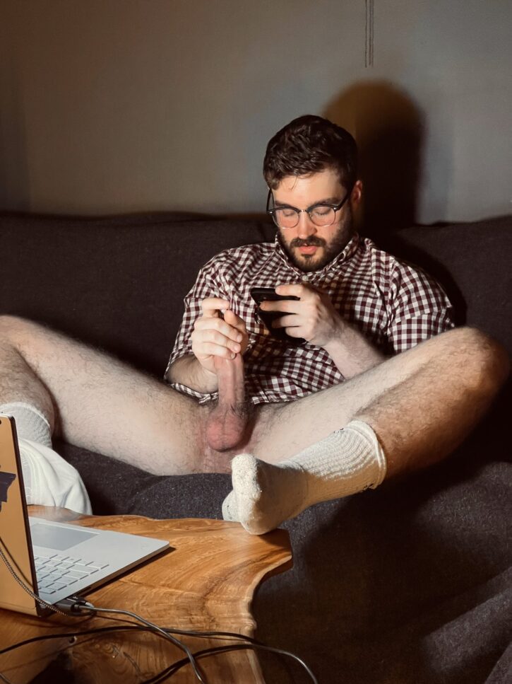 Forest Cliff wearing a checkered button shirt with white socks jerking off his hard dick while surfing on his phone