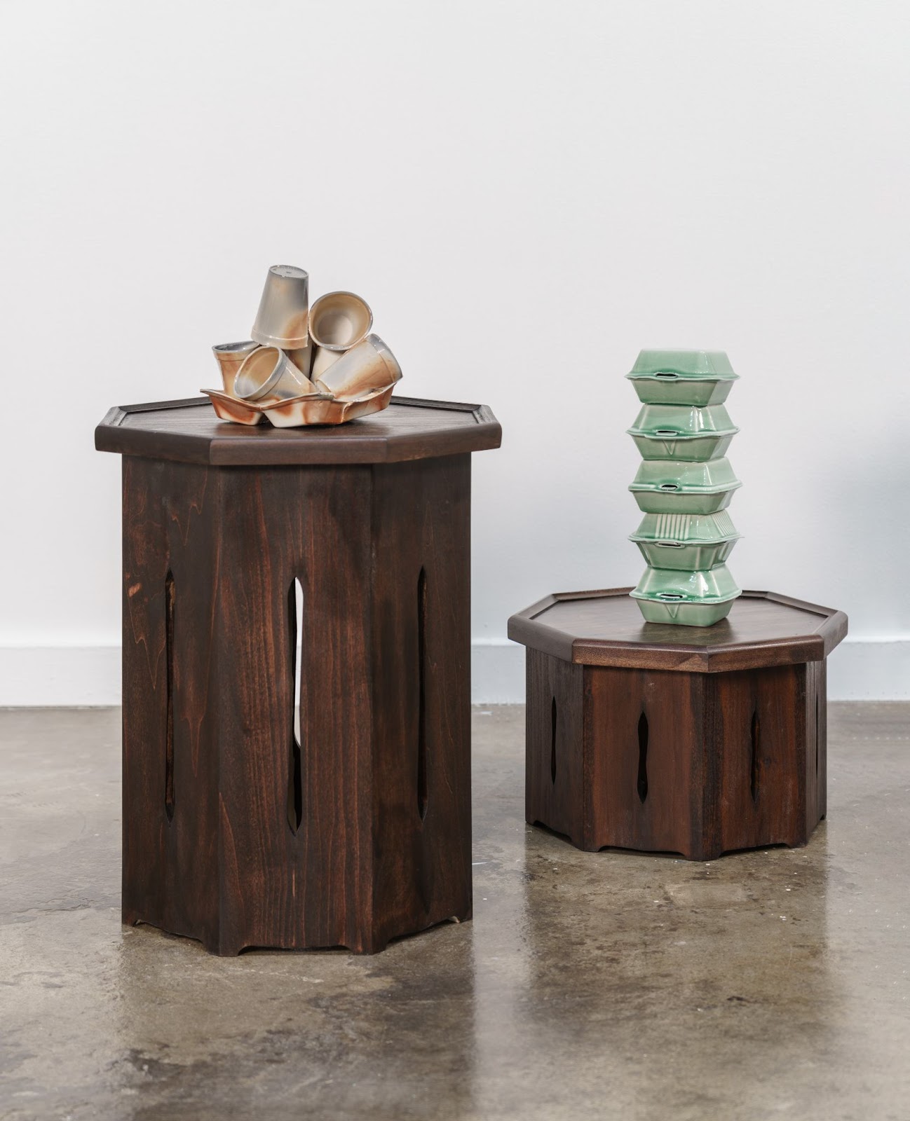 Image: Installation view, Generally Meant to be Discarded. Two wooden soban with porcelain casts of takeout containers and styrofoam cups. Image courtesy of the artist, photo by E.G. Schempf.
