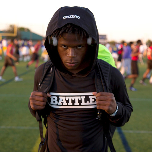 High school age football player wearing black Battle Light Action Hoodie in between 7v7 games
