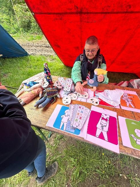 A person sitting at a table with art and craft items

Description automatically generated