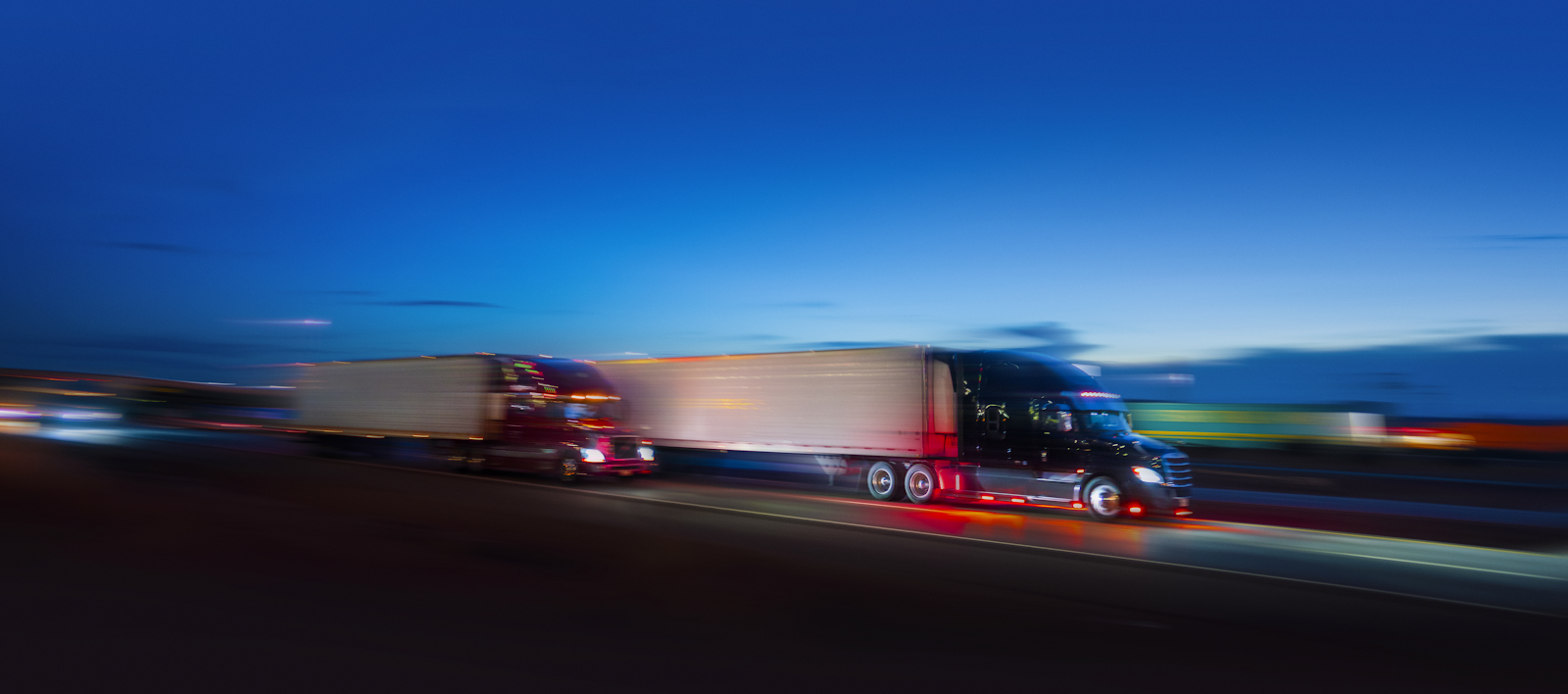 large commercial trucks driving on a highway