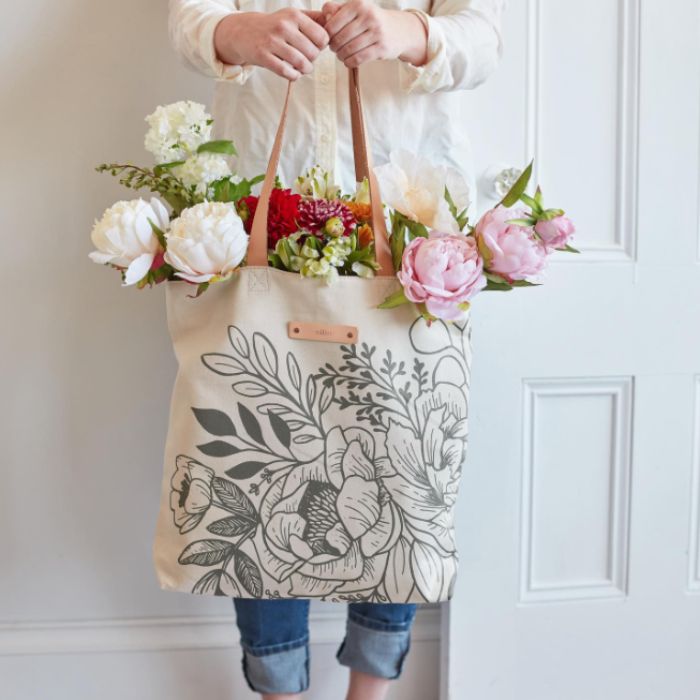 woman holding a custom tote from minted filled with flowers