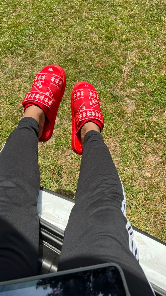 Close up view of a black pants and the kappa slides