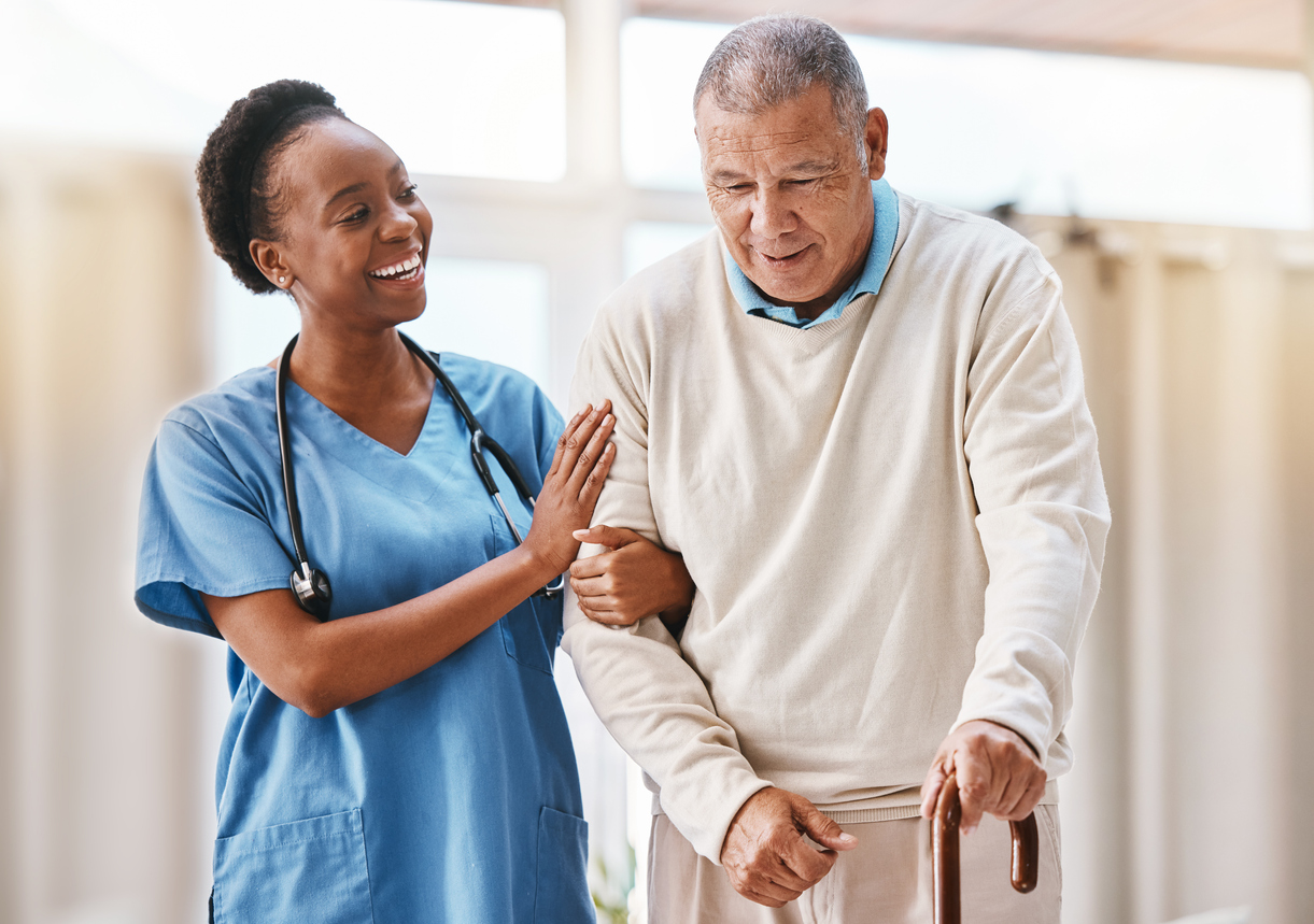 Nurse helping senior with cane
