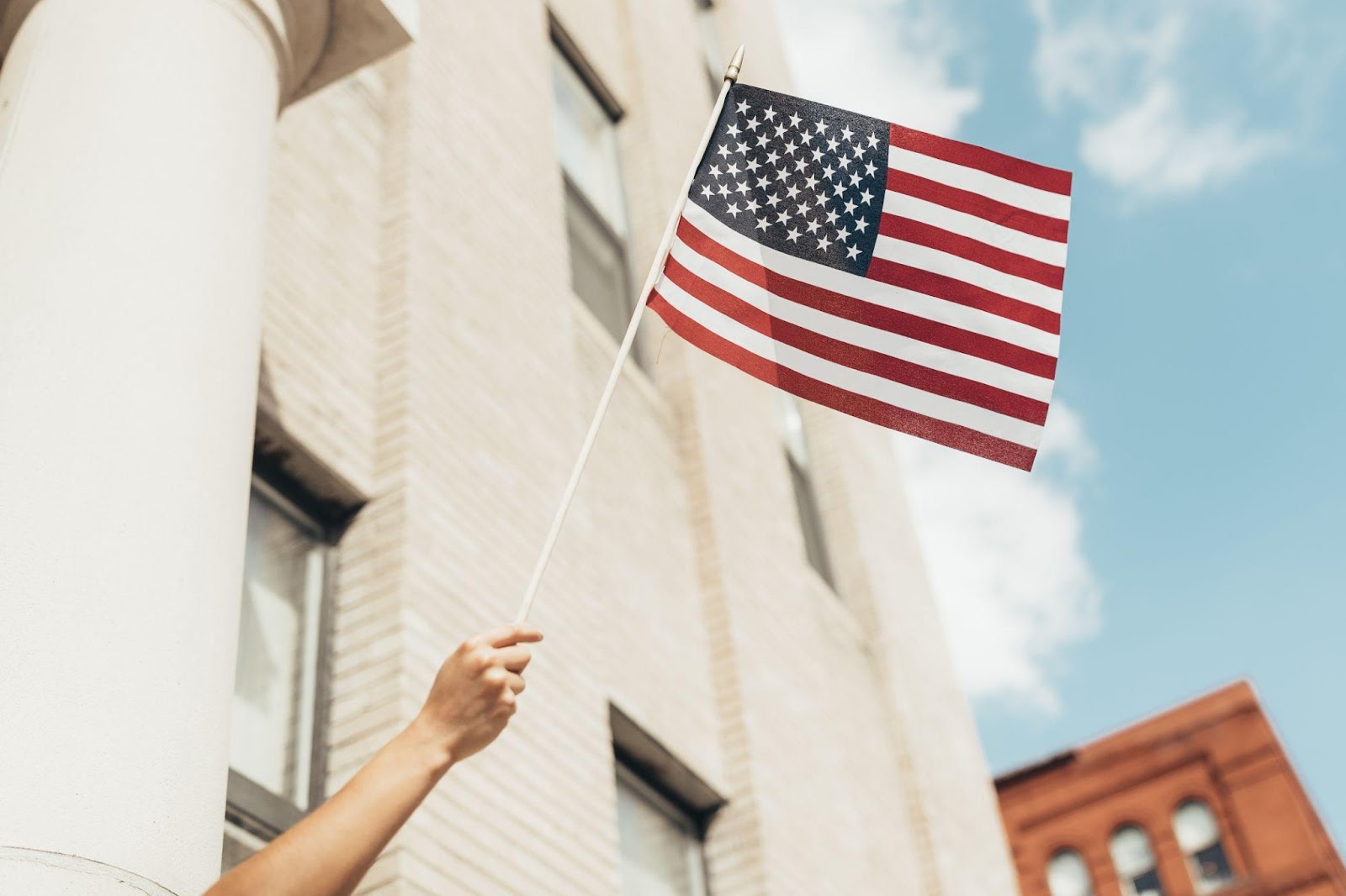 a person holding up an American flag