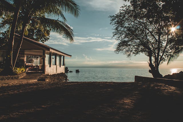 An oceanside property surrounded by palm trees.